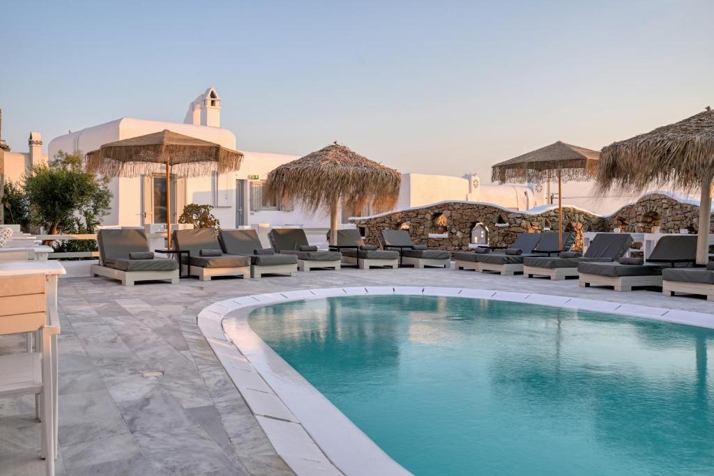 a swimming pool with lounge chairs and a resort at Nodo Boutique Hotel in Mikonos