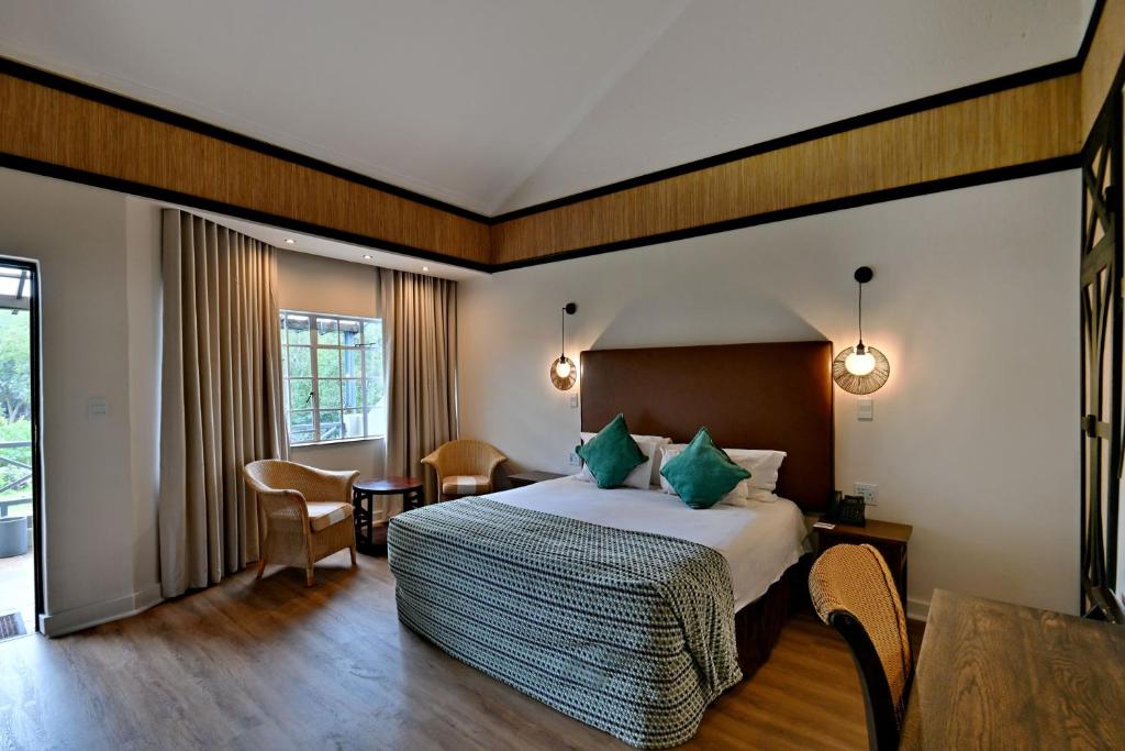 a hotel room with a bed and a table and chairs at Glenburn Lodge & Spa in Muldersdrift