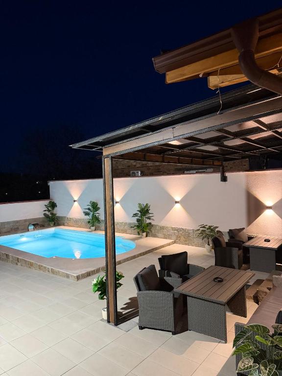 an outdoor patio with a swimming pool at night at Алтъна Калофер in Kalofer