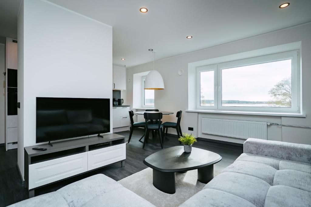 a living room with a couch and a flat screen tv at Sea view apartment Haapsalu in Haapsalu