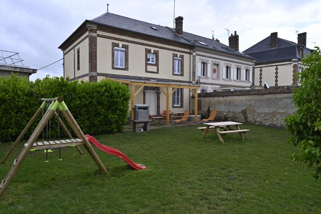 a house with a playground in the yard at gîte MAELYSE in La Neuve-Lyre