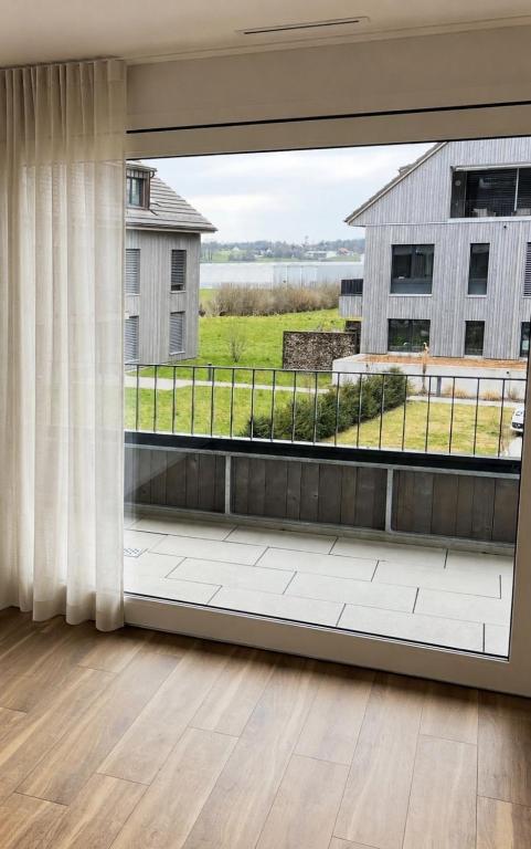 an empty living room with a large window at Modern Nature Apartment ! WIFI & Parking Free ! in Frauenfeld