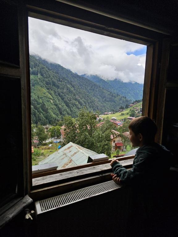 a child looking out of a window at a mountain at HEVAS Suite in Ayder Yaylasi