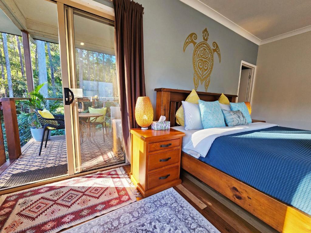 a bedroom with a bed and a balcony at Cosy Studio with Forest Views, Noosa Hinterland in Doonan