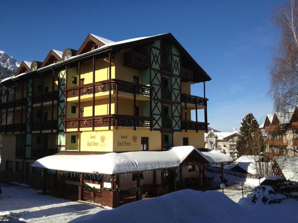 een gebouw met sneeuw op de grond ervoor bij Hotel Dal Bon in Andalo
