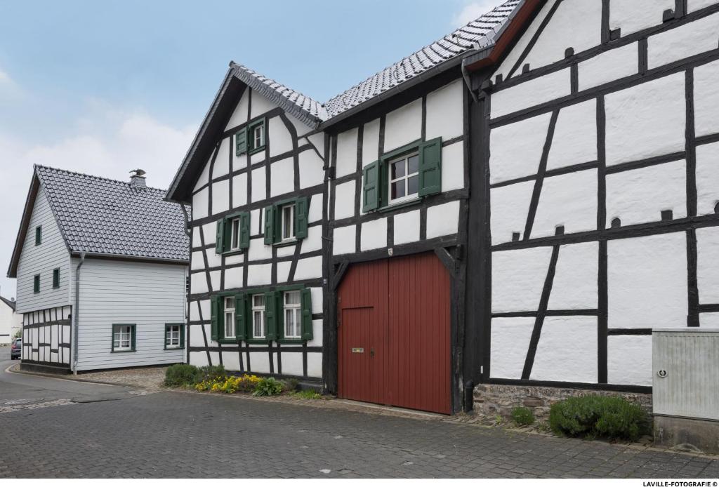 a black and white building with a red garage at BeiArnold in Schleiden