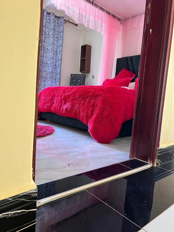 a reflection of a bedroom with a red bed in a mirror at Sylvan hotel in Kasangati