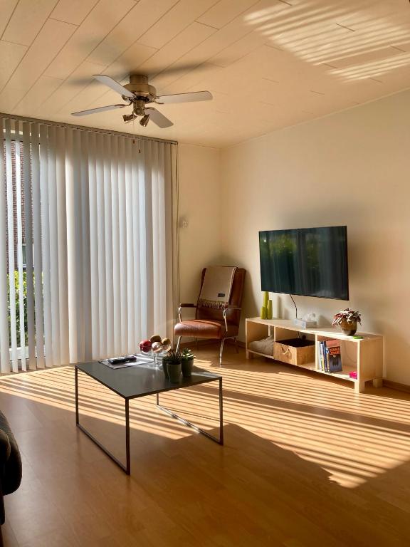 a living room with a table and a tv at Aoja in Maasmechelen