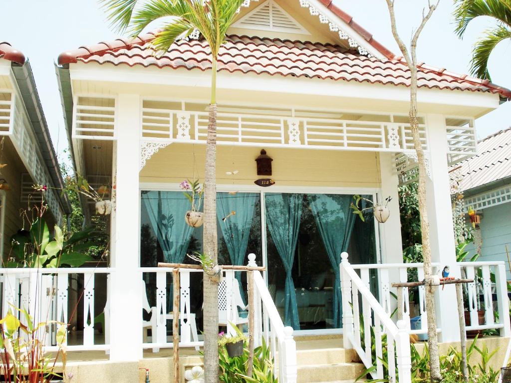 a house with a palm tree in front of it at Prathana Garden Beach Resort in Hua Hin