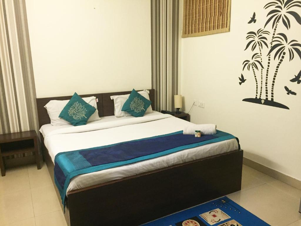 um quarto com uma cama com almofadas azuis em Anantkoti Hotel em Nova Deli