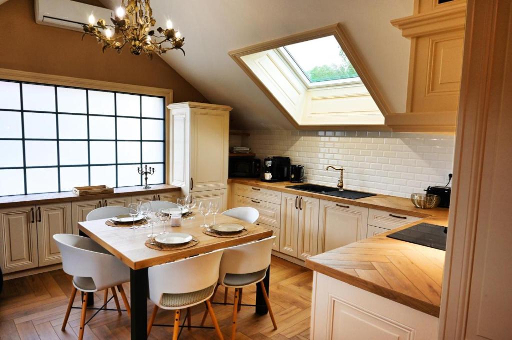 a kitchen with a table with chairs and a window at La Suite Enchantée in Valentigney