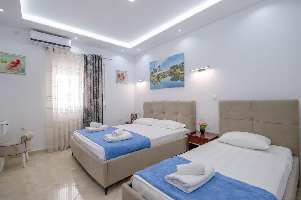 a bedroom with two beds with towels on them at Ksamil Guesthouse Villa in Ksamil