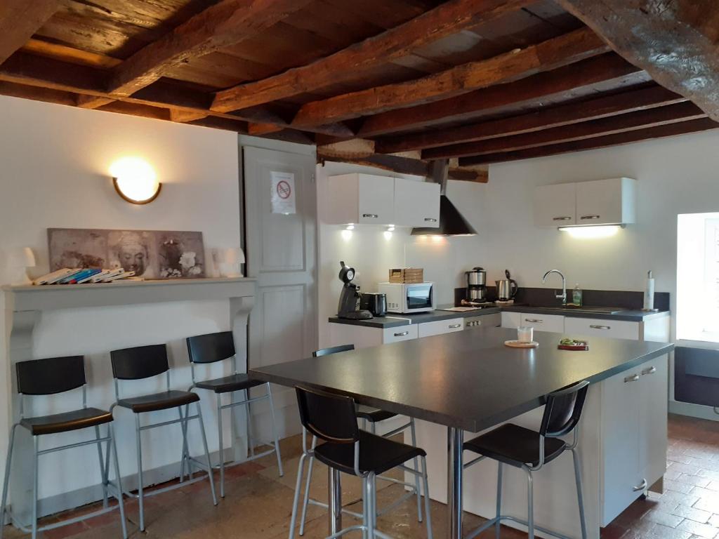 a kitchen with a table and chairs in a room at Gite des Celliers in Alise-Sainte-Reine