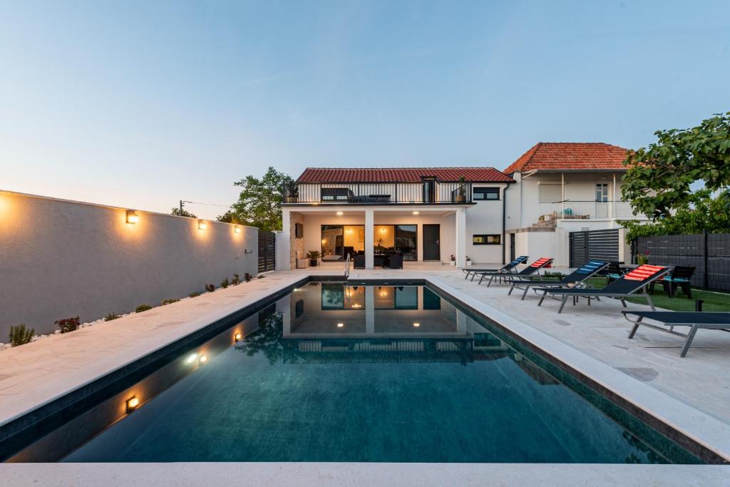 a swimming pool in the backyard of a house at Villa Flora Zadar Villas in Perušić Benkovački