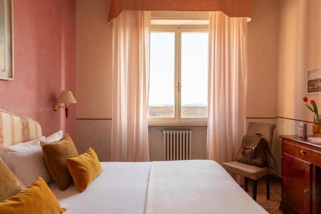pokój hotelowy z łóżkiem i oknem w obiekcie Hotel La Pace w Pizie