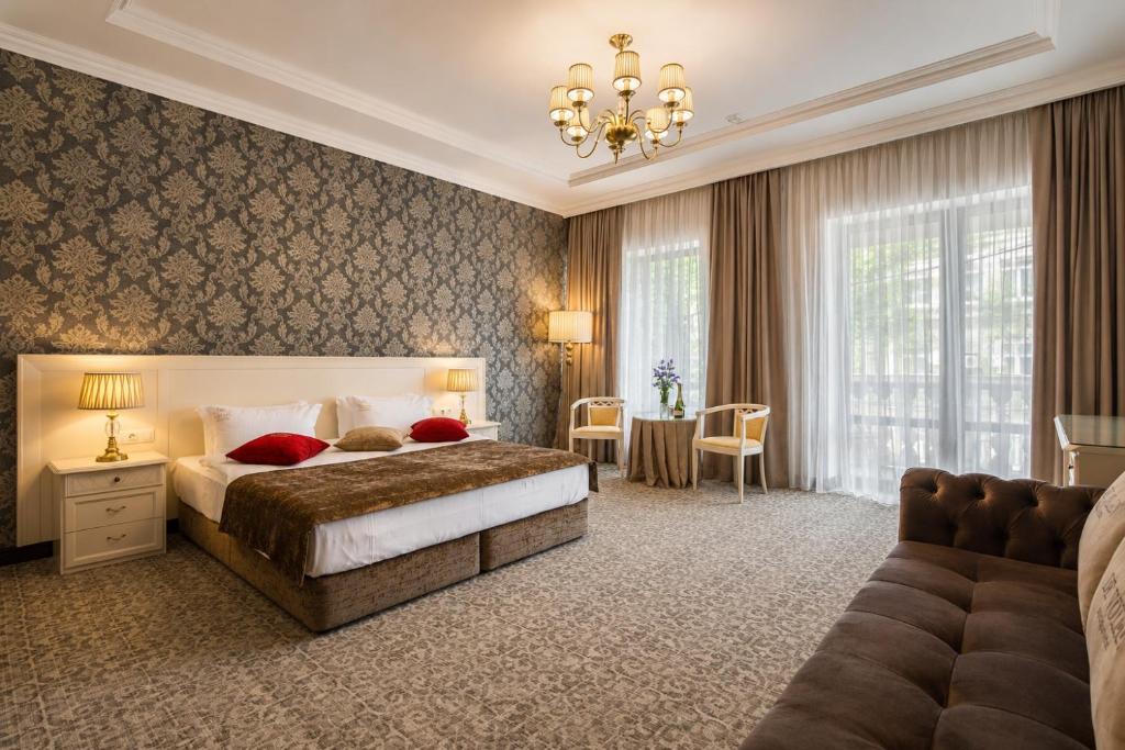 a bedroom with a large bed and a couch at De Volan Boutique Hotel in Odesa