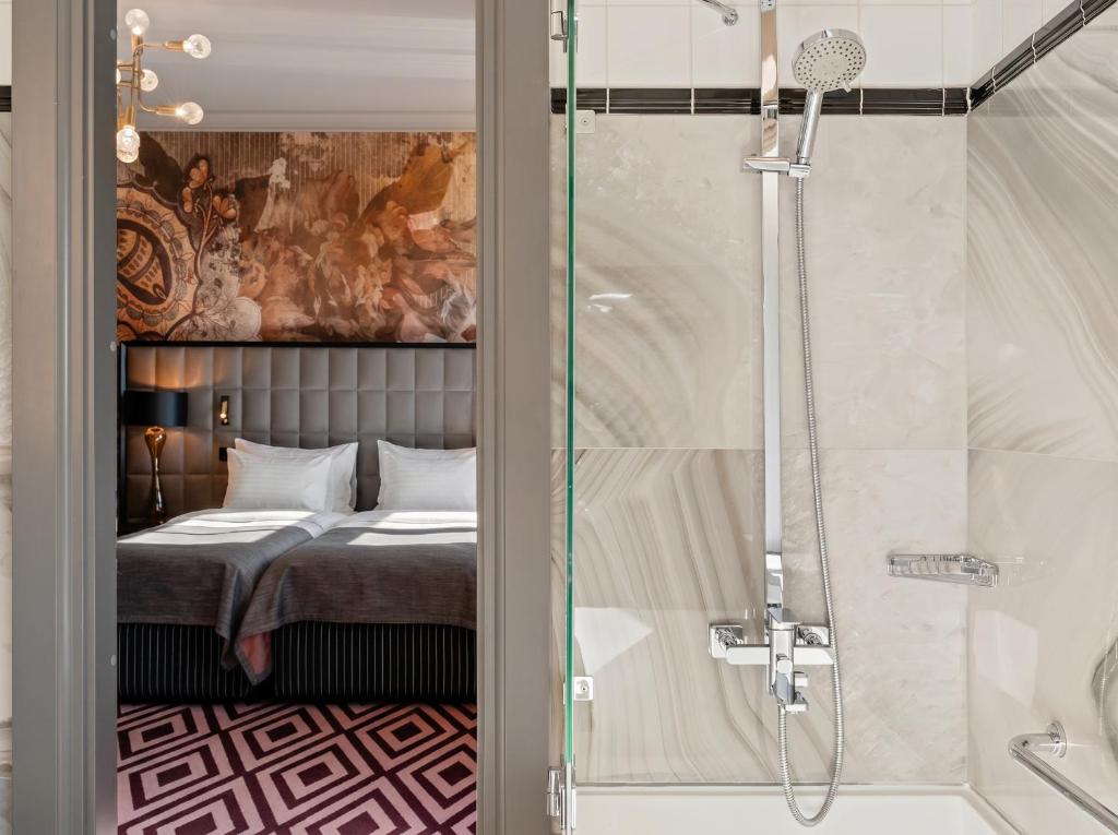 a bedroom with a bed and a shower with a glass door at Grand Poet Hotel and SPA by Semarah in Riga