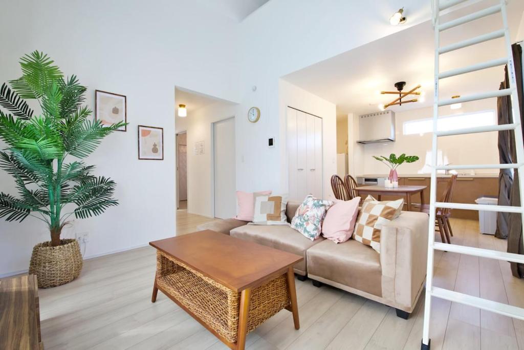 a living room with a couch and a table at Dual Residence Nakijin A in Koechi