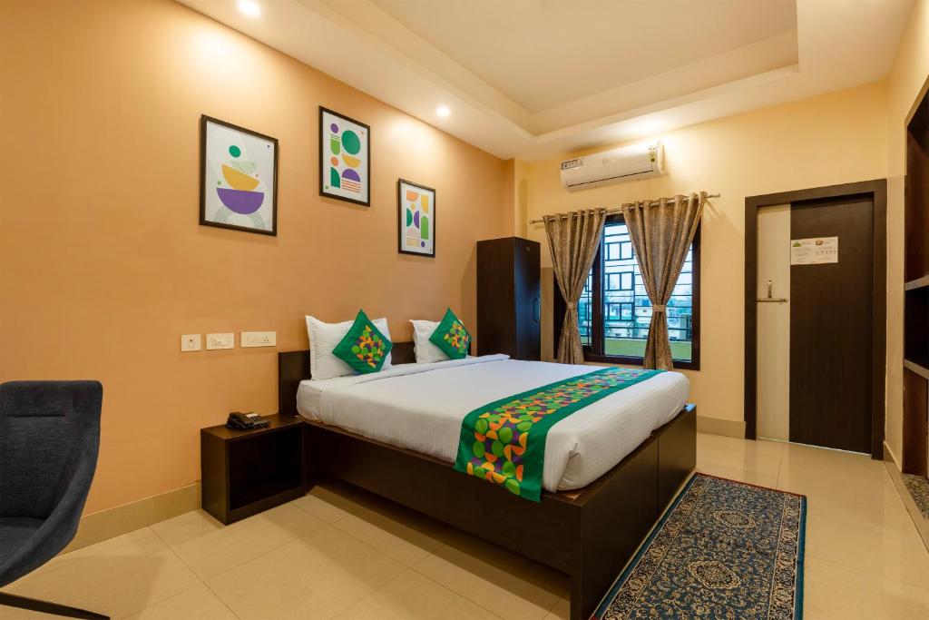 a bedroom with a bed and a chair in a room at Treebo Hotel Mobi VIP Airport in Guwahati