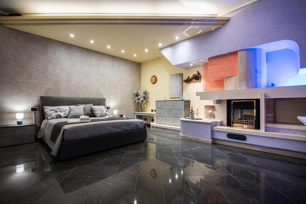 a bedroom with a large bed and a fireplace at Orchidea Catania in San Giovanni la Punta