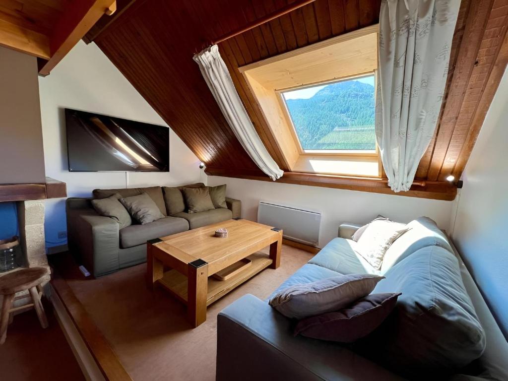 a living room with a couch and a table at Triplex 8 people 4 bedrooms in Saint-Chaffrey