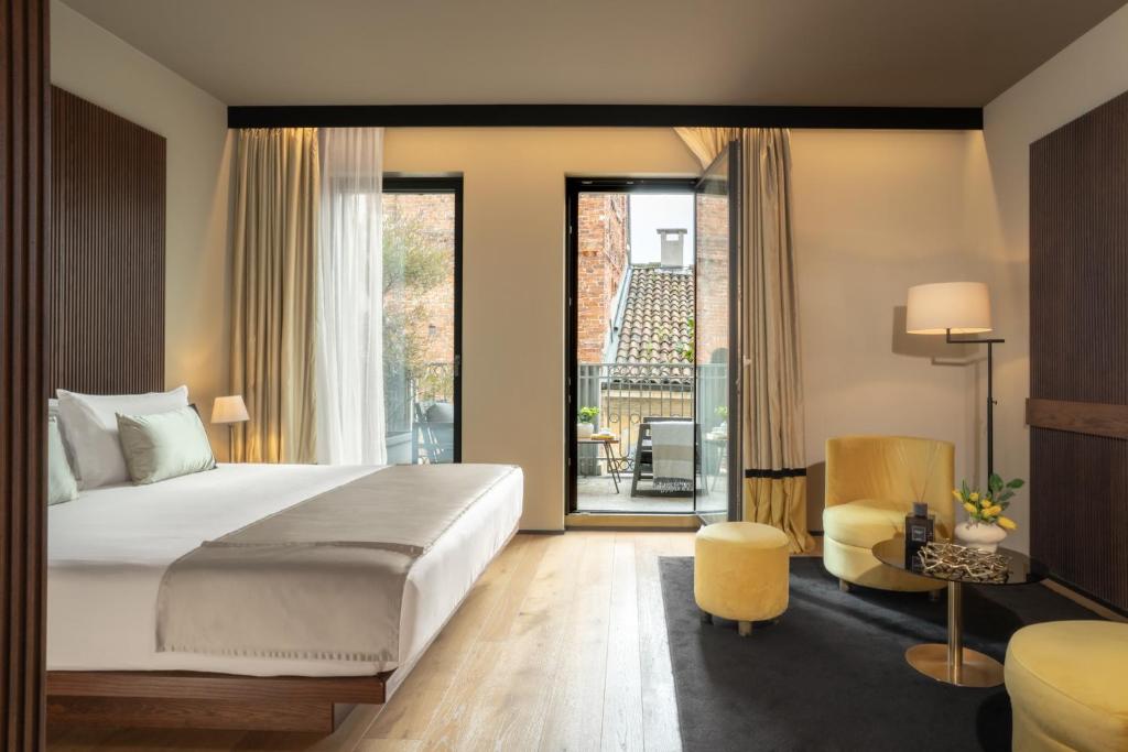 a hotel room with a bed and a balcony at Speronari Suites in Milan