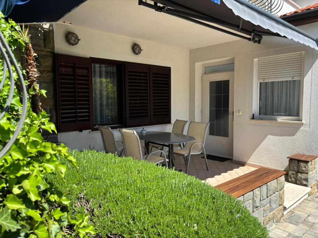 a patio with a table and chairs in a yard at Apartma Eva in Portorož
