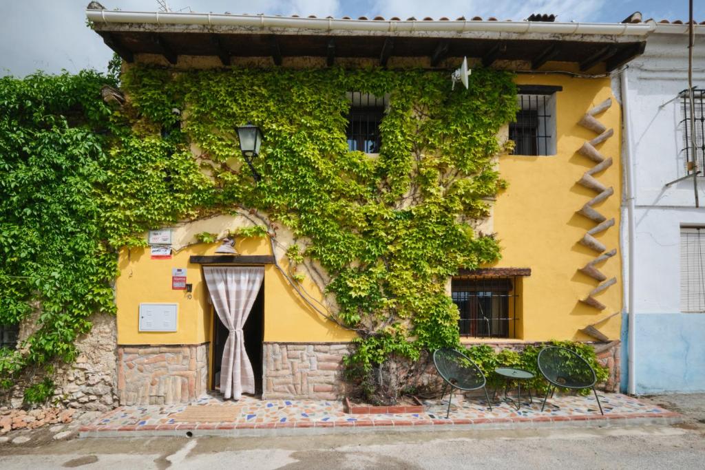 a yellow building with ivy growing on it at Casa Mathilda in Fornes