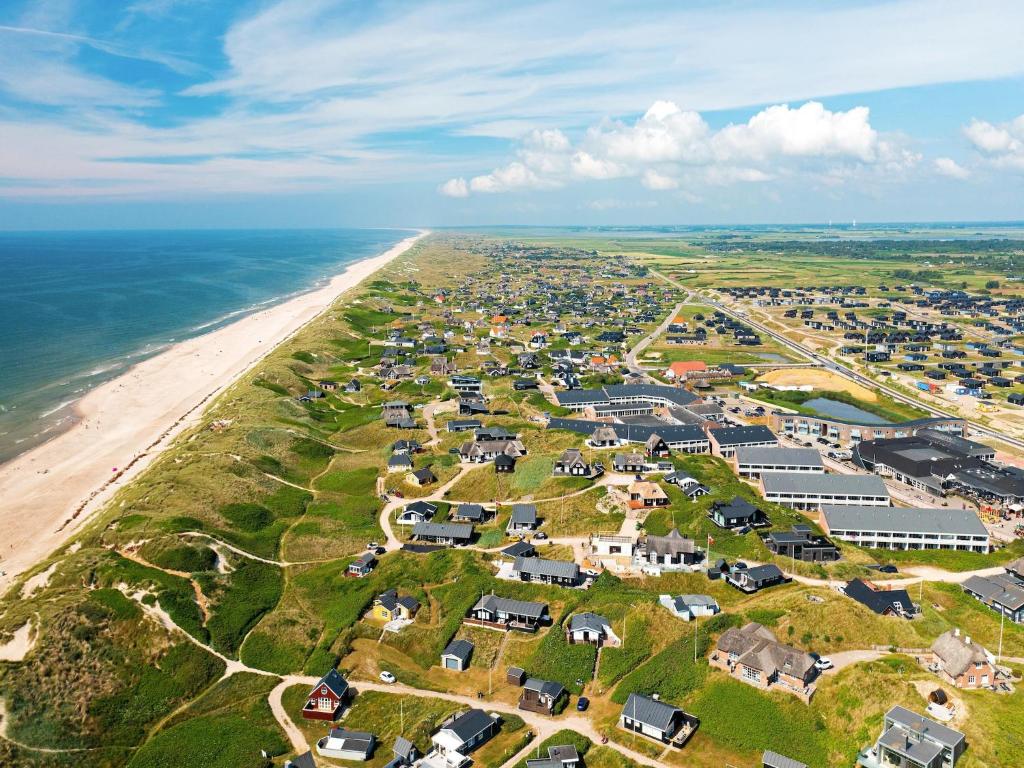 an aerial view of a beach with houses and the ocean at Søndervig Holiday Center in Ringkøbing