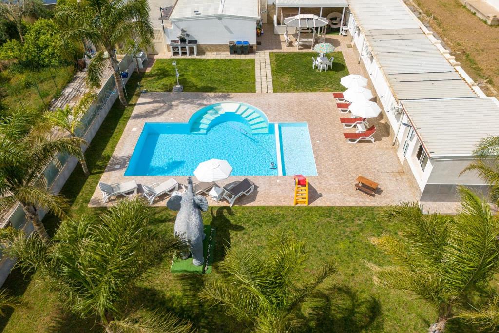 an overhead view of a swimming pool with chaise lounges at Jungle Holiday Villa in Avola