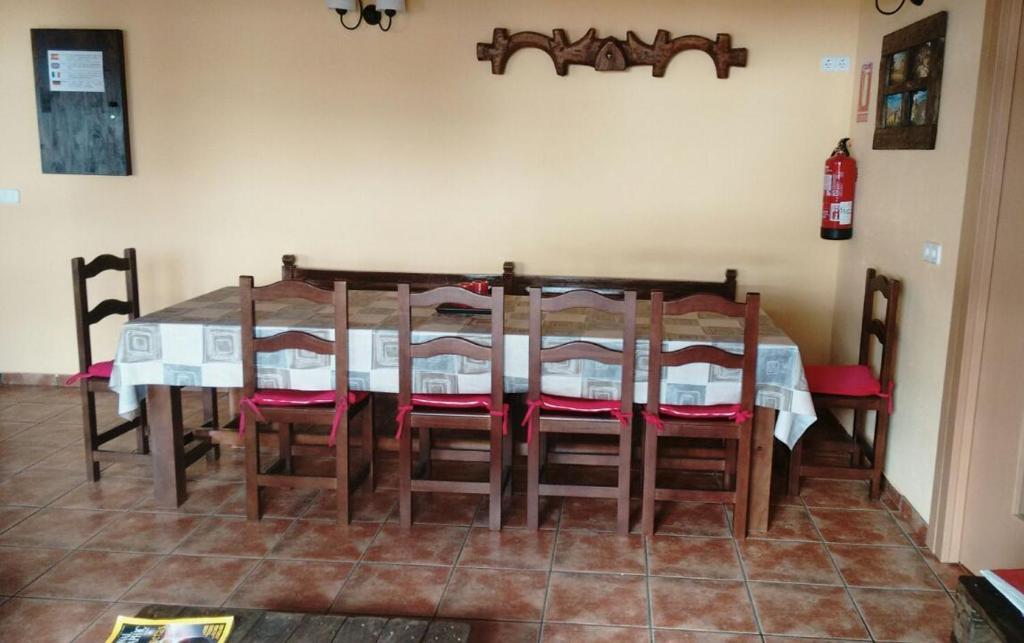 a dining room table with chairs and a white table at Las Candelas de Torreandaluz in Torreandaluz