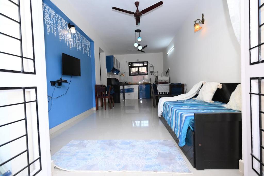 a bedroom with a bed and a blue wall at 400 m from thE beach 1bhk in Colva