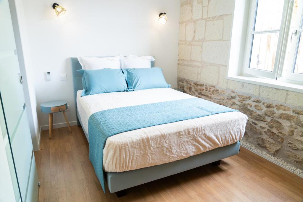 a small bedroom with a bed with blue pillows at Parnaydisiaque in Parnay