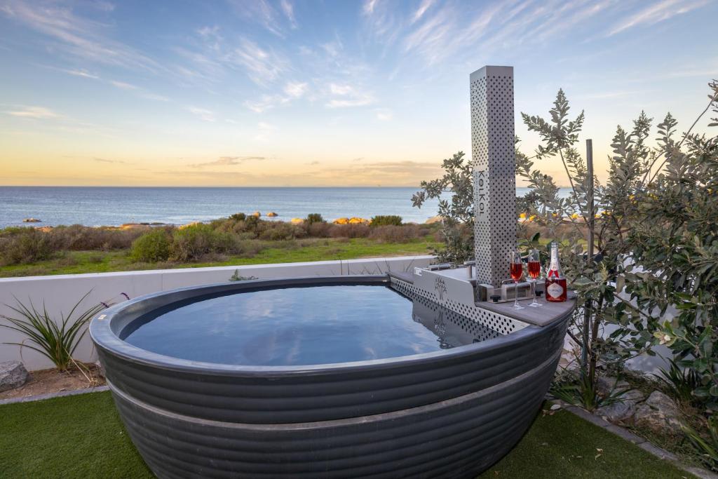a large metal bath tub sitting on top of a yard at Taluga Beach Villa in St. Helena Bay
