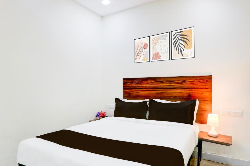 a bedroom with a white bed with a wooden headboard at Super Collection O SS BLUE INN in Hyderabad