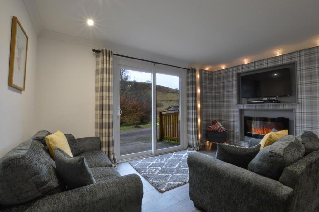 a living room with two couches and a fireplace at Muck in Oban