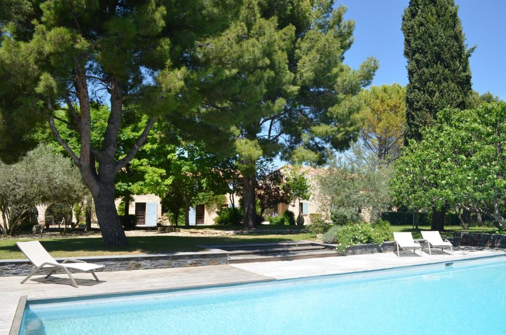 a swimming pool with two lounge chairs and trees at Campagne Chastel in Aix-en-Provence
