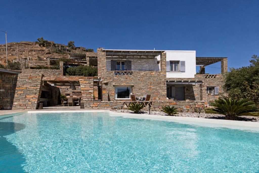 a large swimming pool in front of a house at Relax Joy Villa | Koundouros Kea Beachside in Koundouros