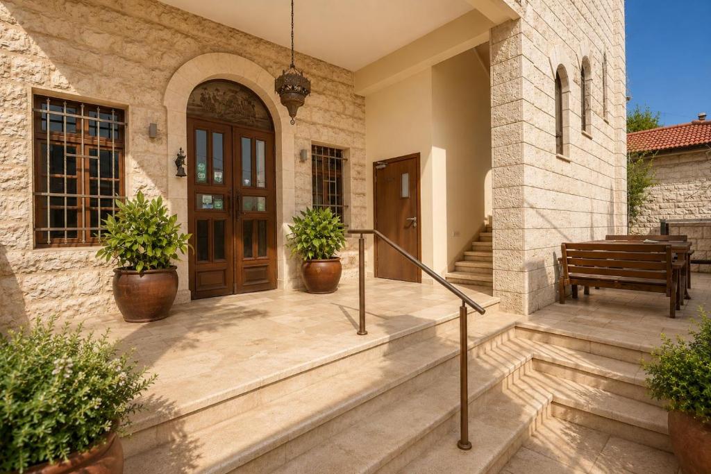 a porch of a house with two potted plants at Villa Nazareth - Boutique hotel in a central location in Nazareth