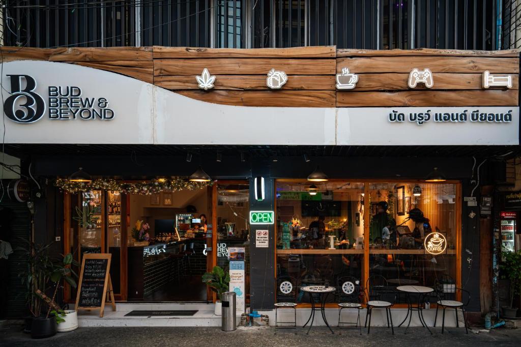 a restaurant with tables and chairs in front of it at Bud Brew Beyond Dispensary and Hotel in Bangkok