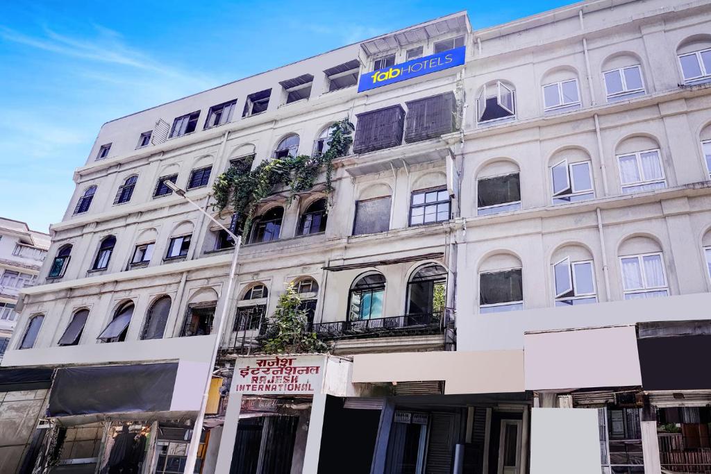 a white building with a blue sign on it at FabHotel Blue Light in Mumbai