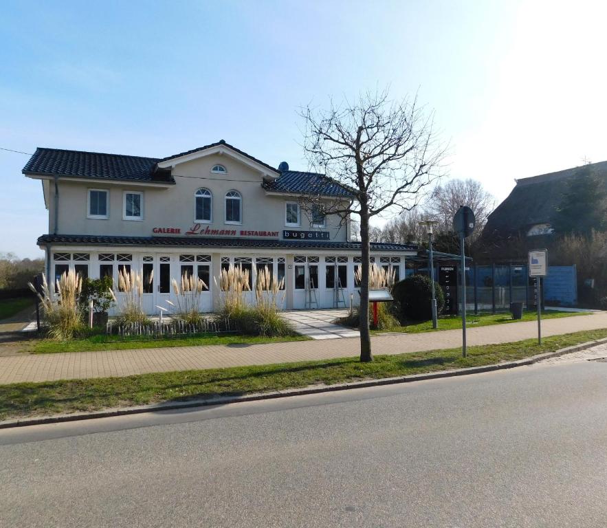 a large white house on the side of a street at Neue Galerie App 3 in Ahrenshoop