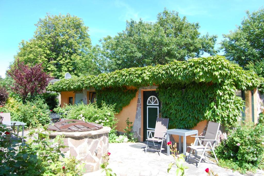a small house with a green ivy covered at Sterntaucher Bungalow App 5 in Ahrenshoop