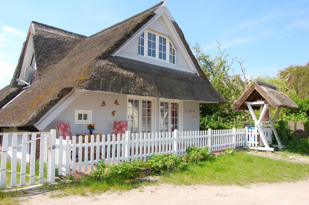 a small house with a white picket fence at Malvenhus in Ahrenshoop