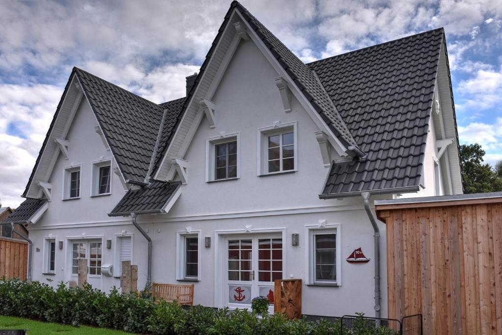 a white house with a black roof at Ostseefeeling in Wustrow