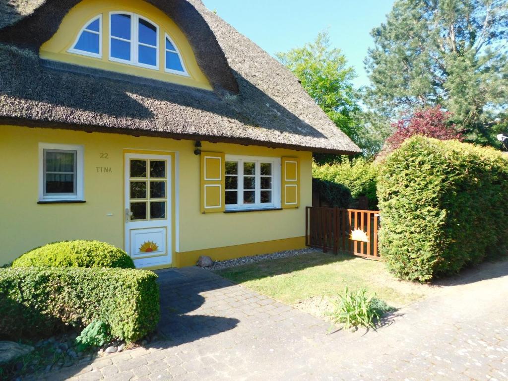 a yellow house with a thatched roof at Haus Tina in Ahrenshoop