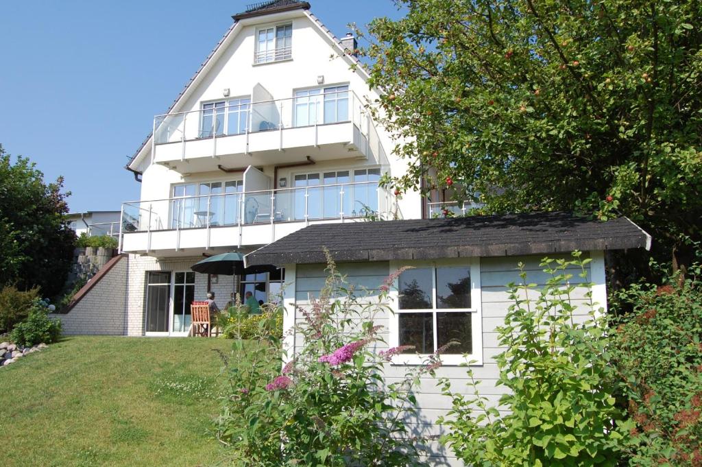 a white house with a balcony and a yard at Suite Meeresrauschen in Ahrenshoop