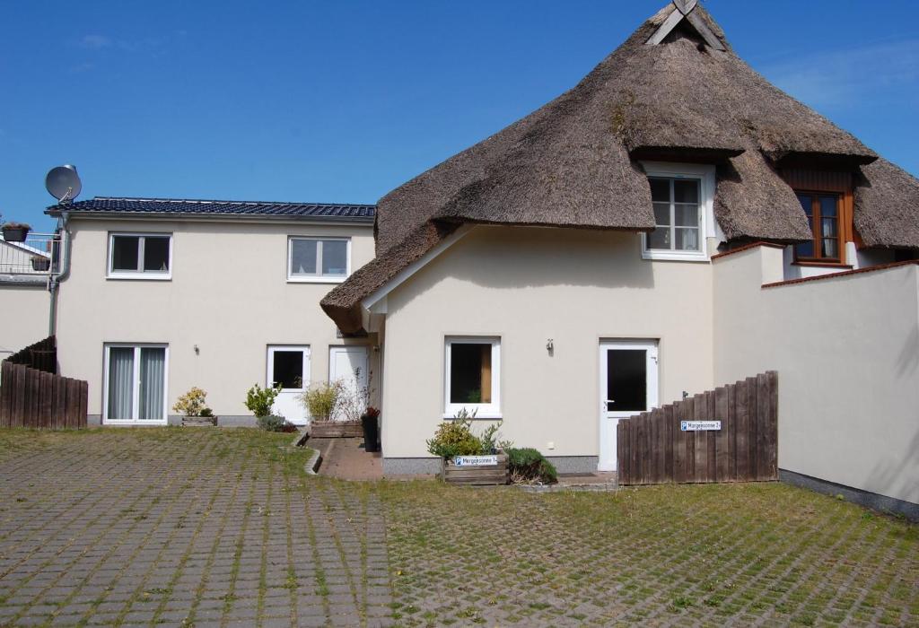 a large white house with a thatched roof at Abendrot in Ahrenshoop