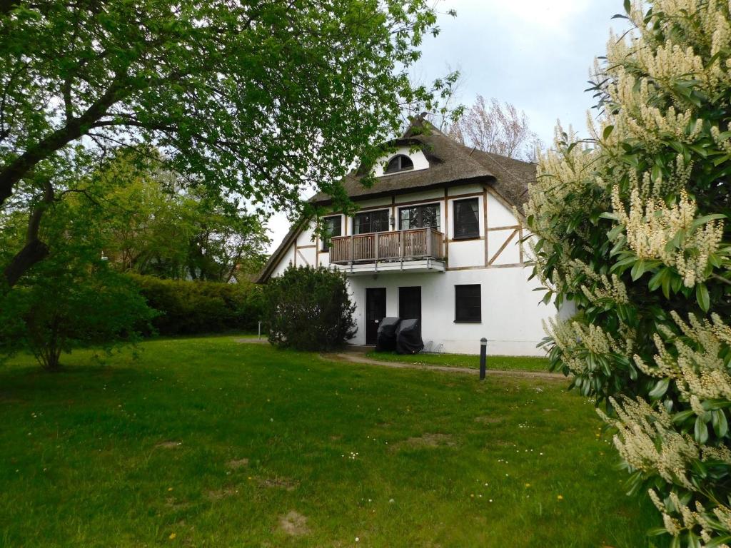 a white house with a balcony on a yard at Luv in Althagen
