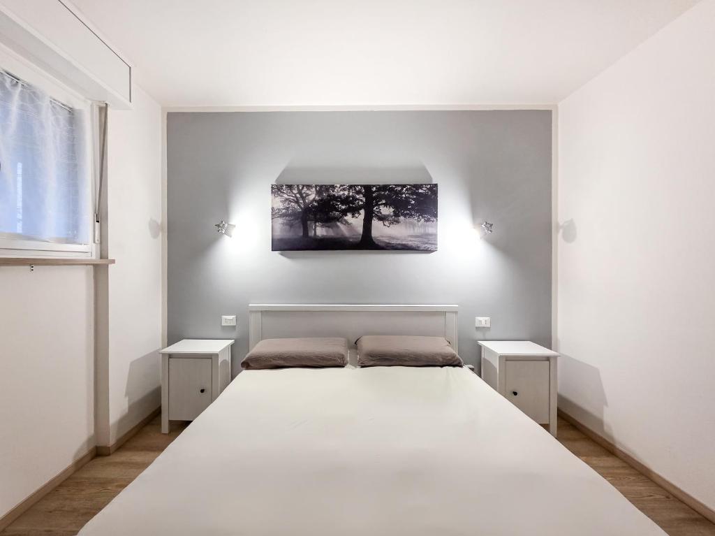 a bedroom with a large white bed with two night stands at B&B Color Rovereto in Rovereto